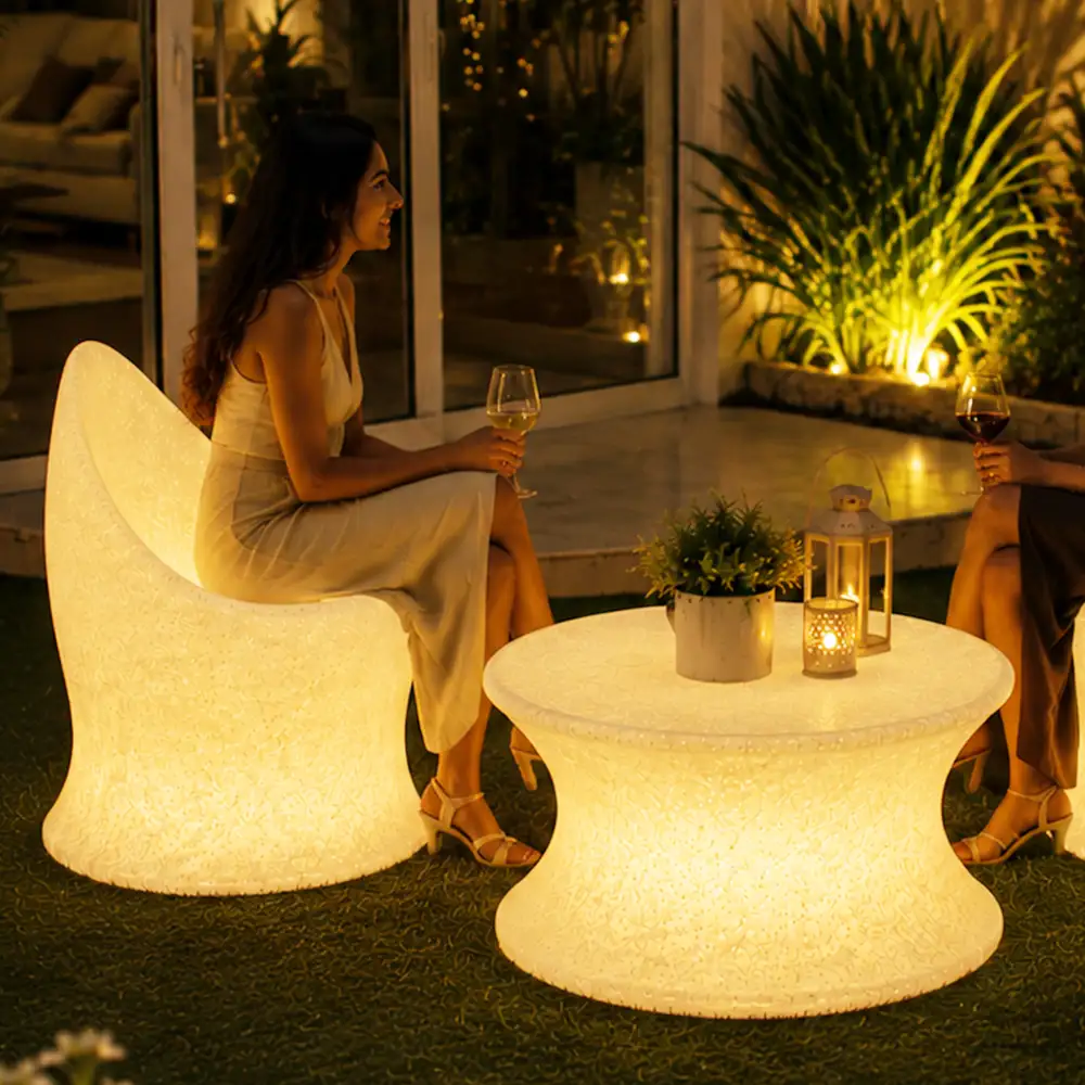 Marvella and Olivia Illuminated Set — LED outdoor chair and coffee table in White Stone glowing at night