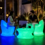 Marvella and Olivia Illuminated Set — LED outdoor chair and coffee table in White Stone glowing at night