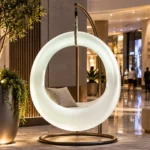 Milo Illuminated Garden Swing — LED outdoor swing in White Stone glowing in a garden at night