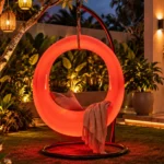 Milo Illuminated Garden Swing — LED outdoor swing in White Stone glowing in a garden at night