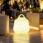 Rio Illuminated Pouffe — LED outdoor stool in White Stone glowing after dark